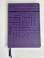 Purple A5 notebook with holographic edges and embossed cover with positive affirmations. Bulleted paper with pocket on the back.