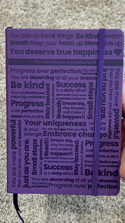 Purple A5 notebook with holographic edges and embossed cover with positive affirmations. Bulleted paper with pocket on the back.