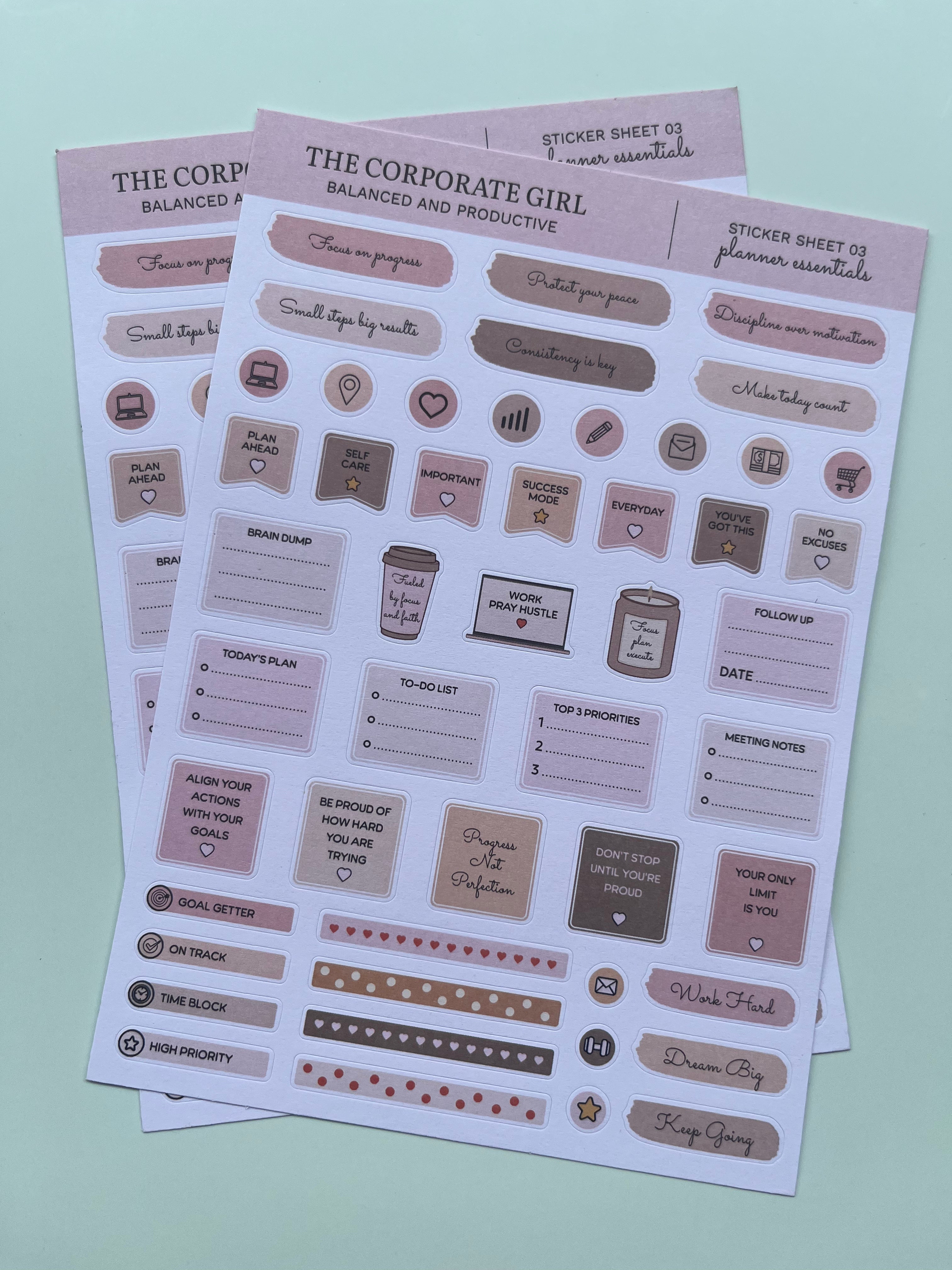Three planner sticker sheets titled 'The Corporate Girl' arranged diagonally on a light mint green background. The stickers feature neutral tones of beige, taupe, and dusty pink with various icons, labels, and motivational phrases for productivity.